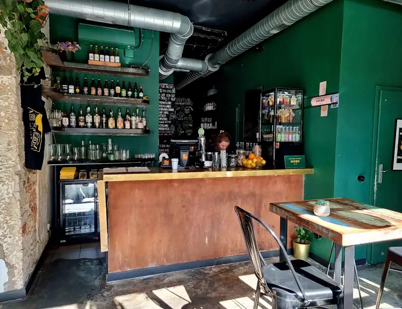 Bar z butelkami na zielonej ścianie