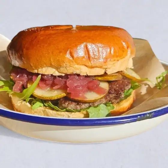 Burger w maślanej bułce na emaliowanym talerzu